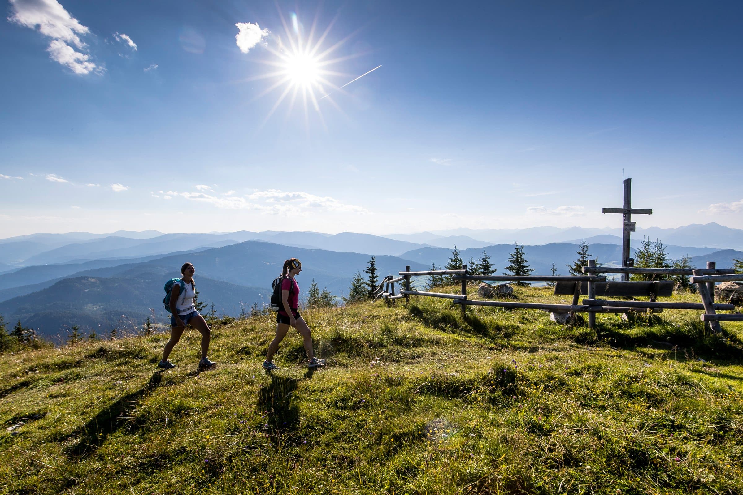 Hiking, two hikers against the light heading towards the summit cross, Grebenzen